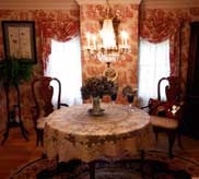 Formal dining room with round table, lace tablecloth and chandelier