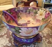 Hand-painted porcelain punch bowl with floral design on decorative stand